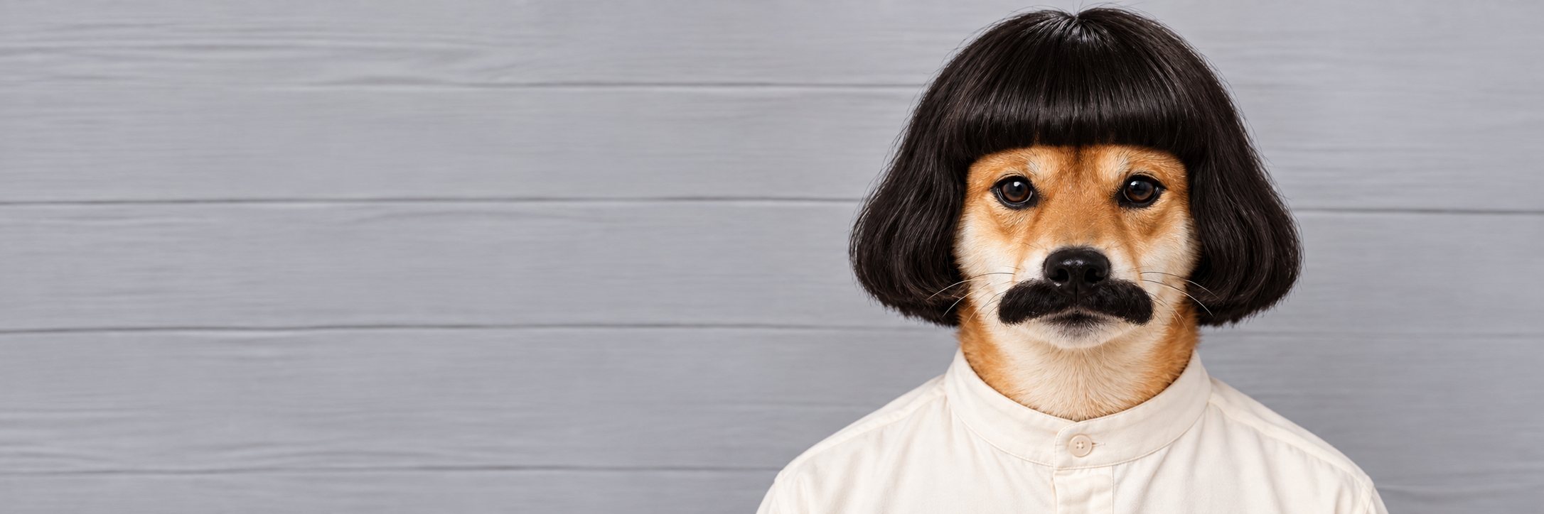 INABU in a cream shirt standing against a grey wooden wall